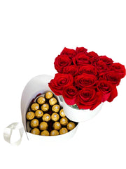 A heart-shaped chocolate box containing red roses and yellow chocolates, presenting a luxurious and romantic gift.