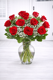 Bouquet of red roses in a clear vase on a white surface