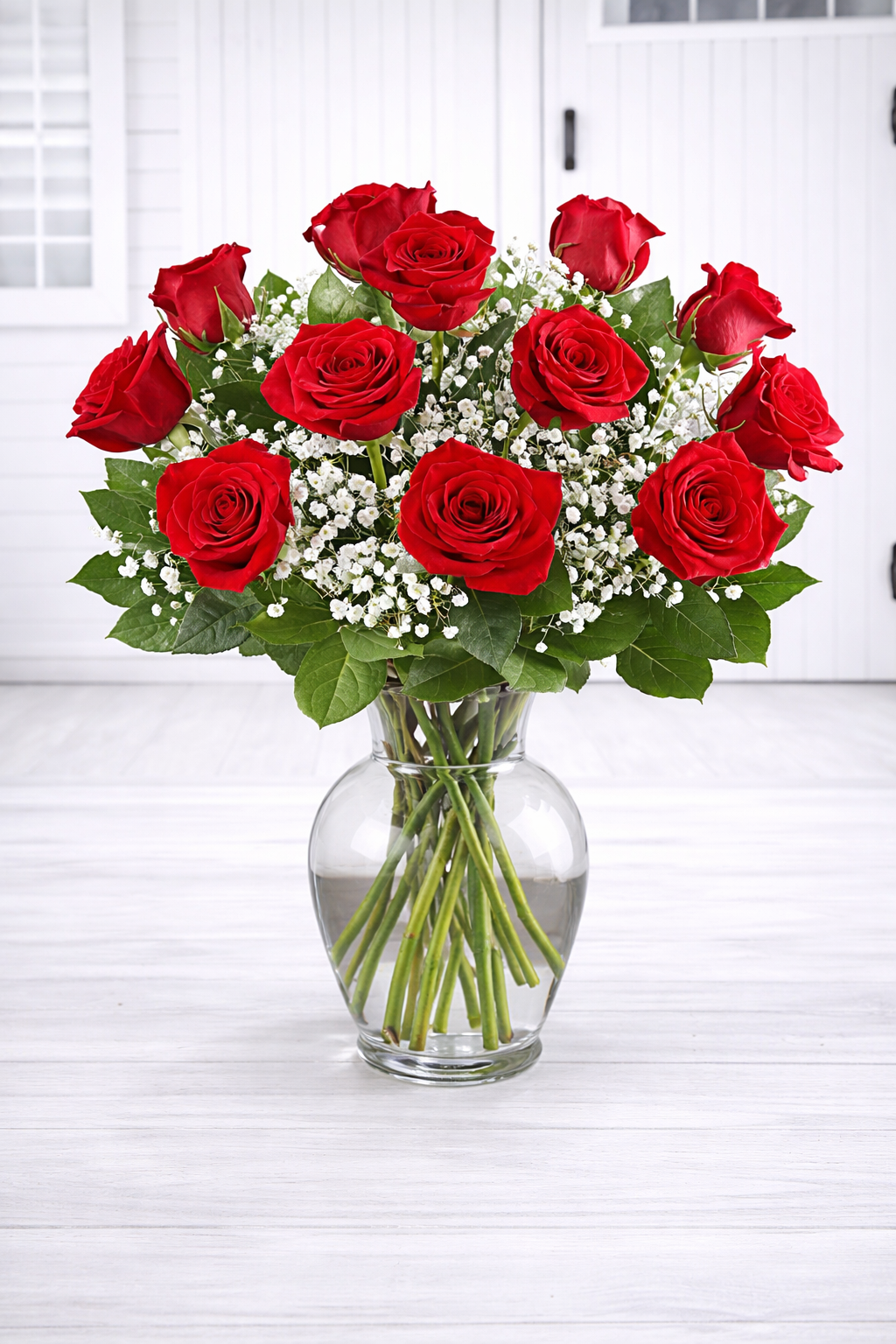 Bouquet of red roses in a clear vase on a white surface