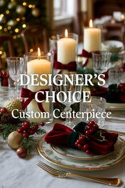 Decorative Christmas table setting with candles, plates, and napkins, featuring 'Designer's Choice Custom Centerpiece' text.