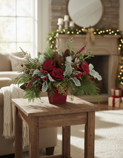 Decorative floral arrangement on a wooden table in a cozy living room with festive decorations.