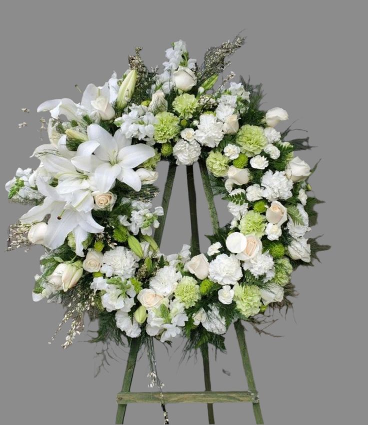 White and green funeral wreath with lilies, roses, carnations and hydrangeas on easel – sympathy flowers for funeral service delivery in McKinney Texas